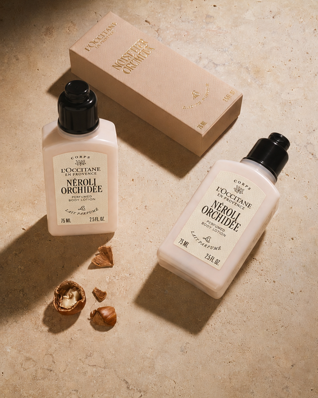 L'Occitane Noisetier Cremeux shower gel and body lotion next to a gift box and hazelnuts